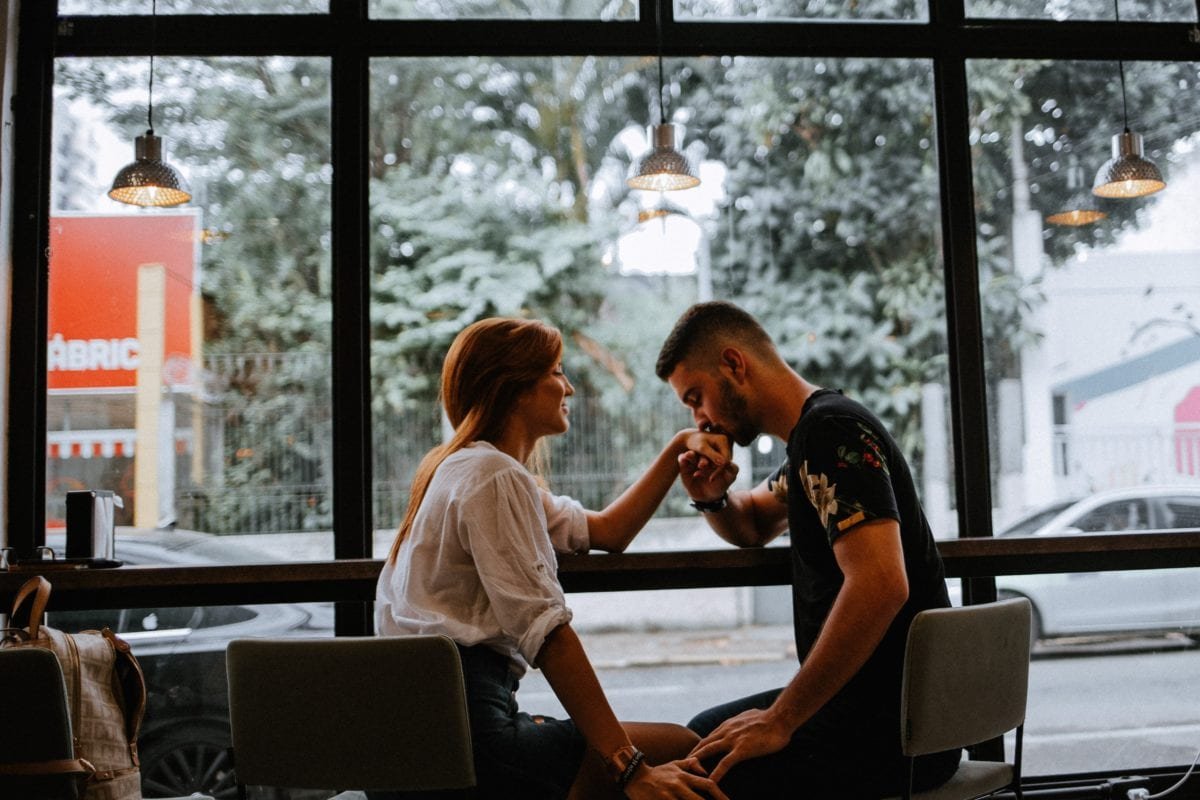 A guy kissing a girl on her hand