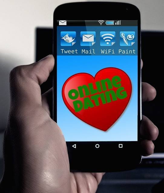 A hand holding phone with online dating written on the screen